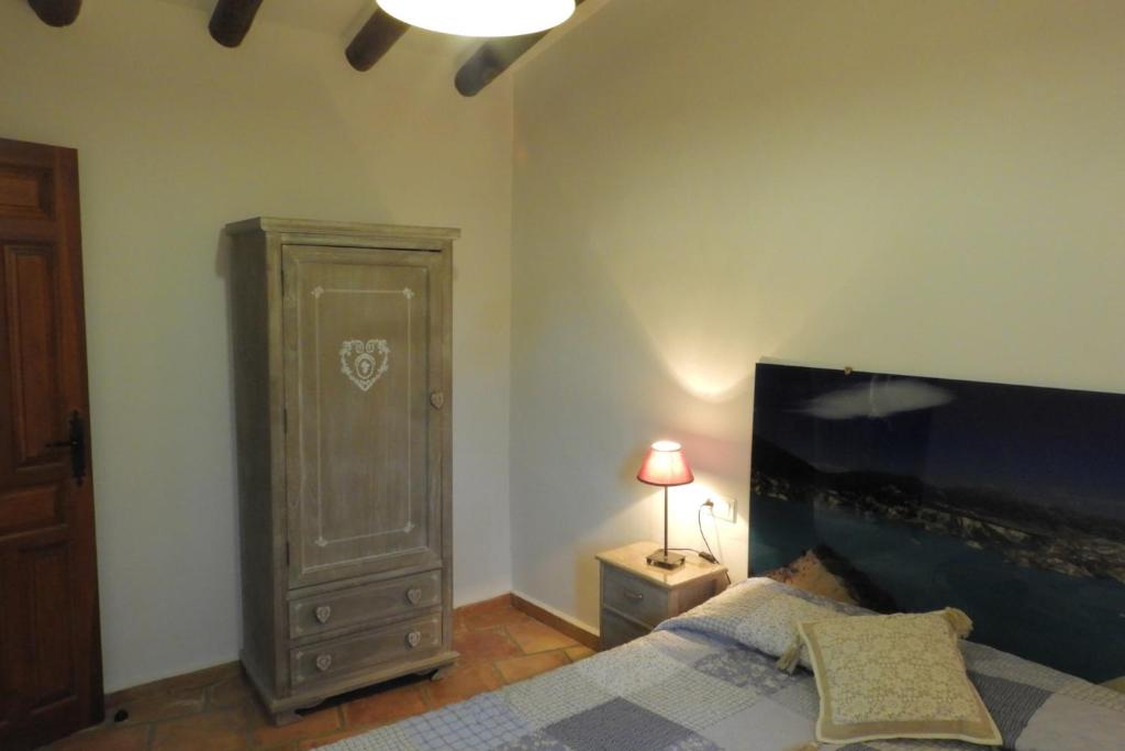 um quarto com uma cama, uma cómoda e um candeeiro em Alojamientos Rurales Cortijo Las Golondrinas em Alhama de Múrcia