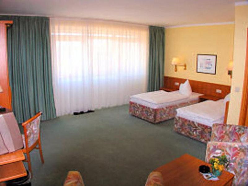 Habitación de hotel con 2 camas y mesa en TOP Motel Sassnitz, en Lanken