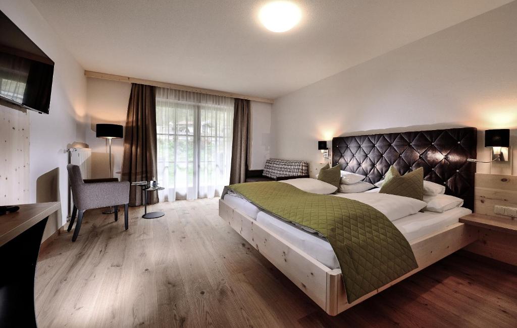 a large bedroom with a large bed and a desk at Die Waldruhe in Kartitsch