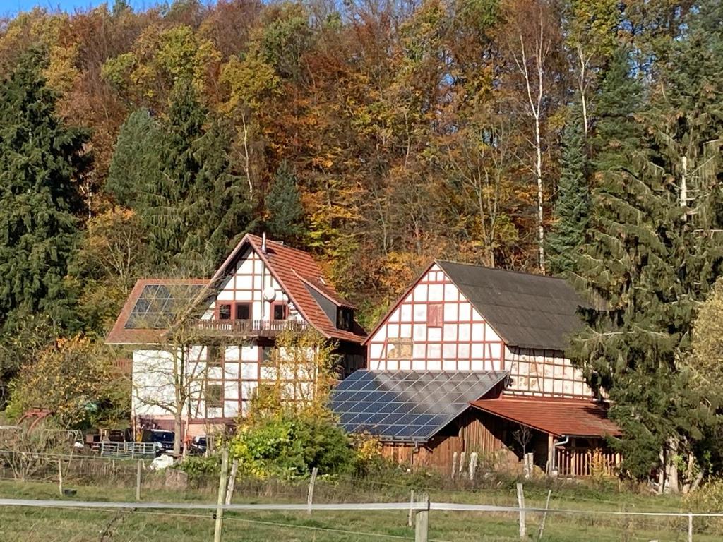 uma grande casa de madeira com painéis solares em Große Ferienwohnung auf Pferdehof Mitten in der Natur 
