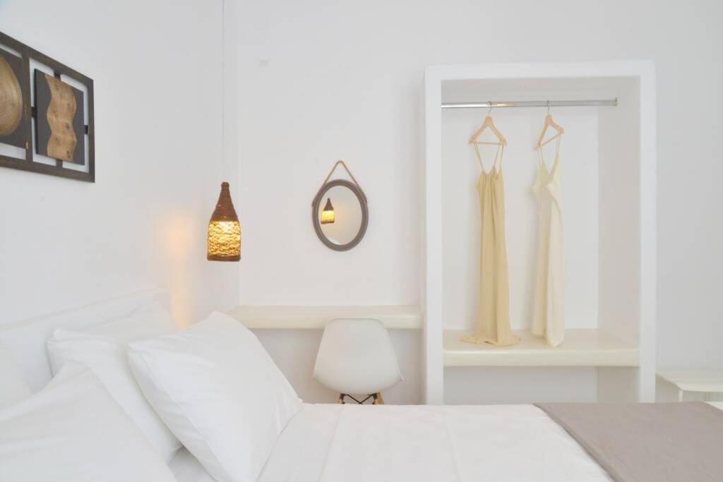 a white bedroom with a white bed and a chair at Casa Mare Pollonia in Pollonia