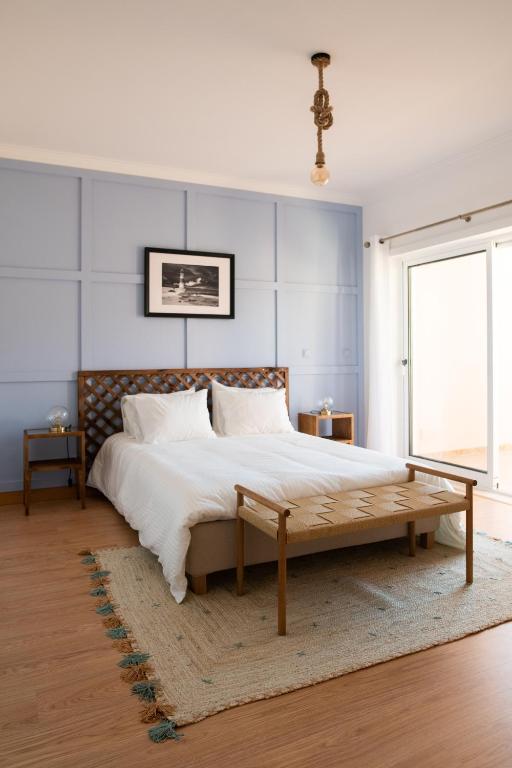 a bedroom with a large bed with a wooden headboard at Casa amigavel do Mar in Sesimbra