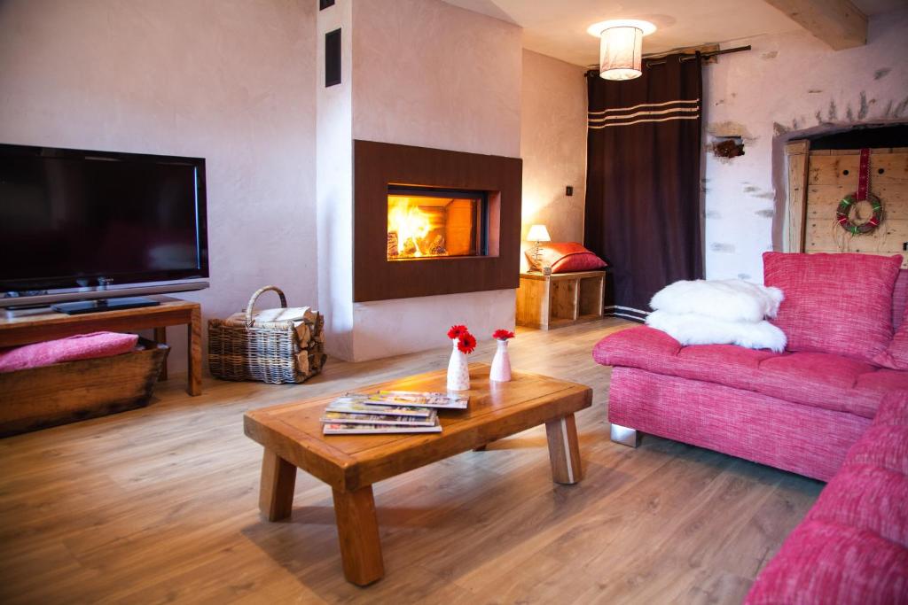 a living room with a couch and a table with a fireplace at Versaya in Bourg-Saint-Maurice