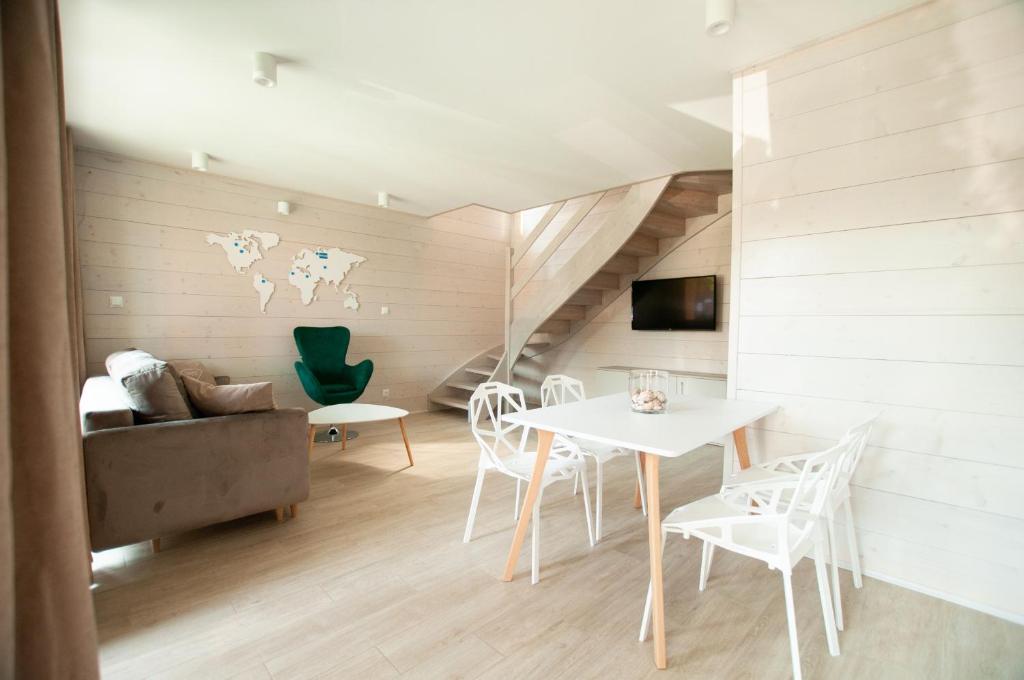 a living room with a couch and a table and chairs at Domki Amber House in Dźwirzyno