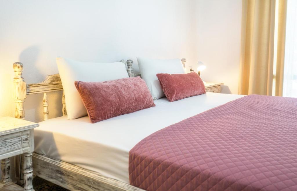 - un lit avec 2 oreillers rouges dans l'établissement Haus Irene, à Potos