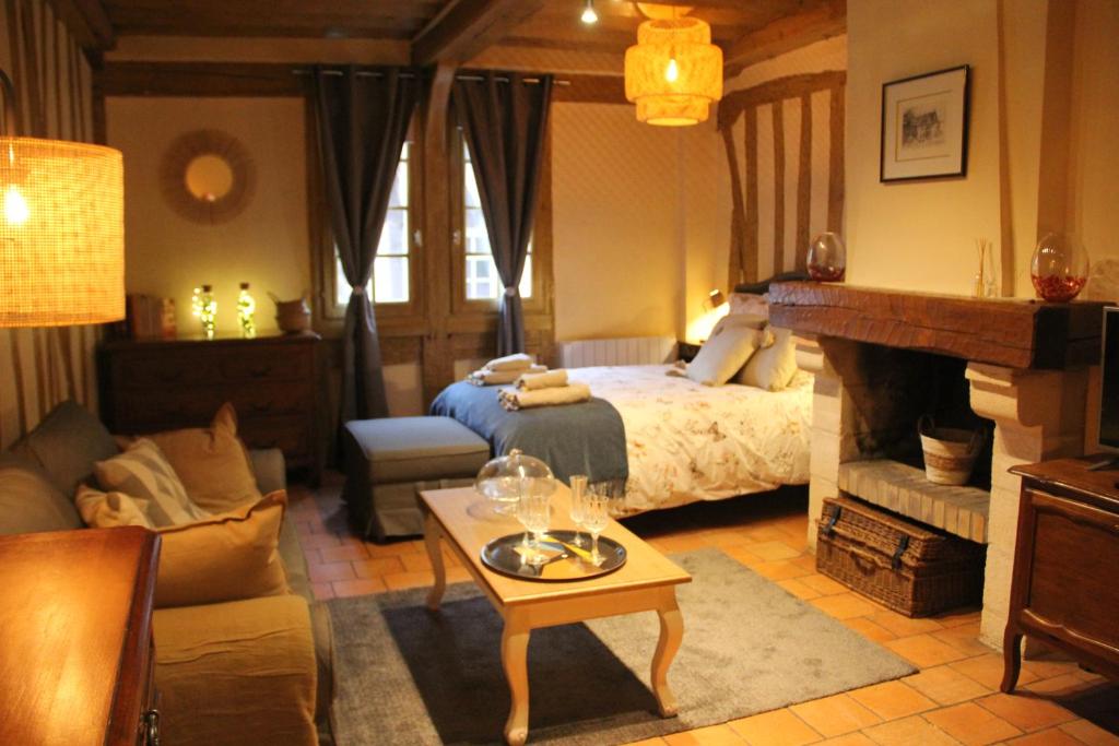 een slaapkamer met een bed en een woonkamer bij Studio Julianne place Sainte Catherine in Honfleur