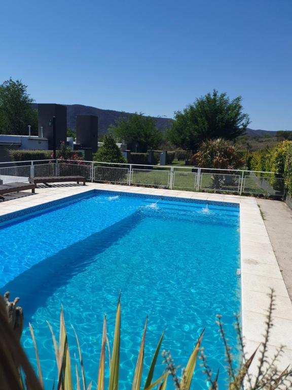 une grande piscine bleue avec de l'eau bleue dans l'établissement Aparts serranos, à San Antonio de Arredondo