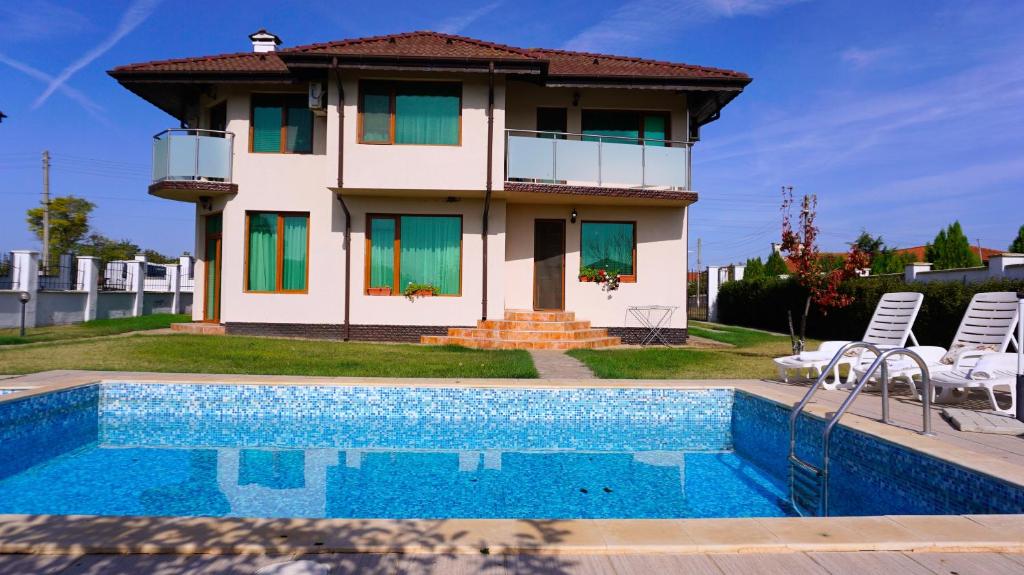 a house with a swimming pool in front of a house at Вила Помело - Family Villa Pomelo in Bŭlgarevo