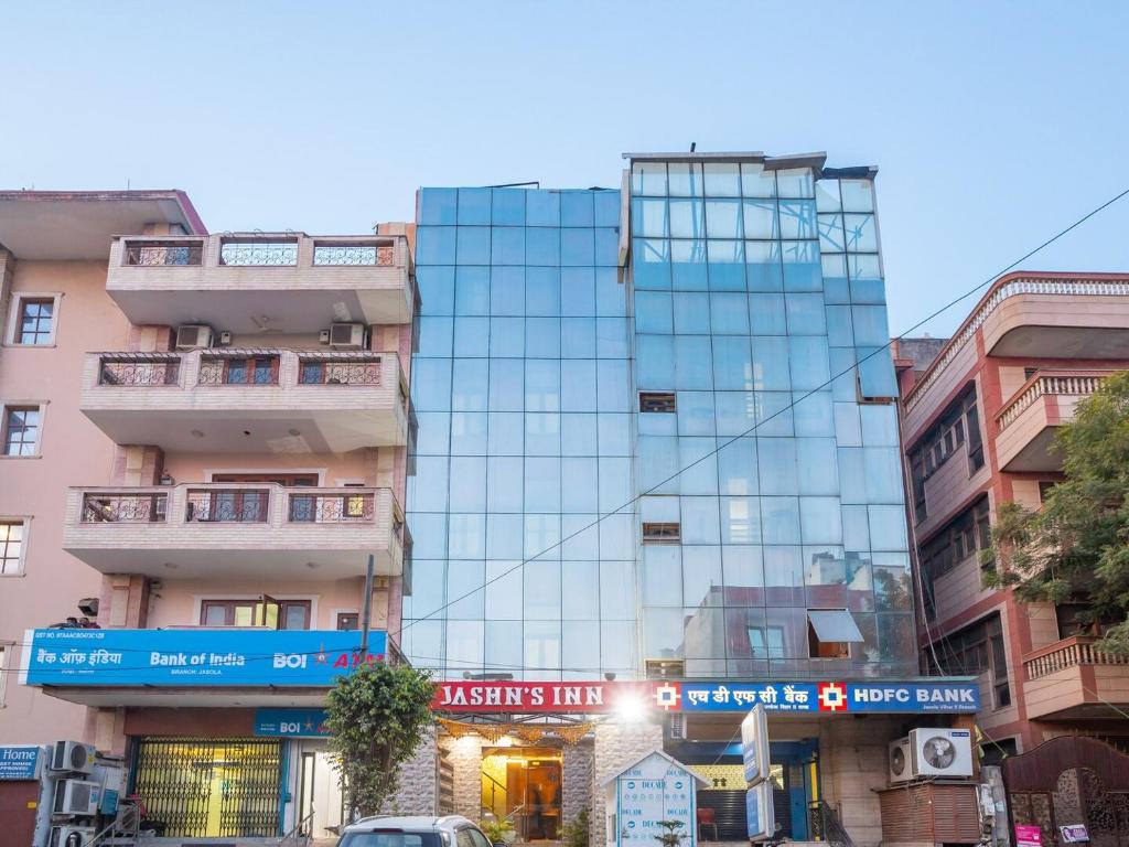 a tall glass building in the middle of a city at Hotel Jashn Inn near Apollo Hospital in New Delhi