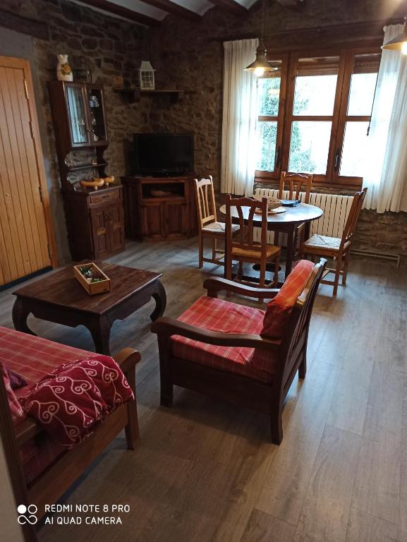 ein Wohnzimmer mit einem Tisch, Stühlen und einem Sofa in der Unterkunft La Catalpa in Arasán