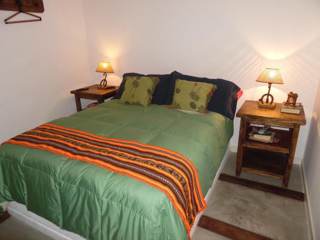 a bedroom with a green bed with two night stands at Casas de Campo Los Corralitos in Mendoza
