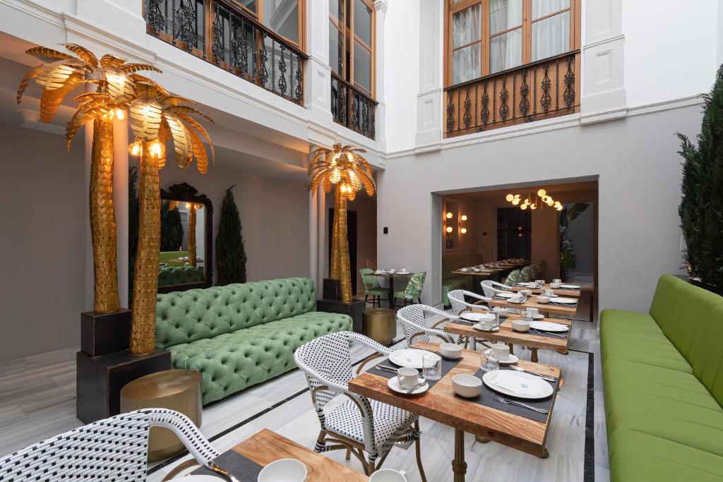 a restaurant with wooden tables and green chairs at Boutique Hotel Cordial Malteses in Las Palmas de Gran Canaria