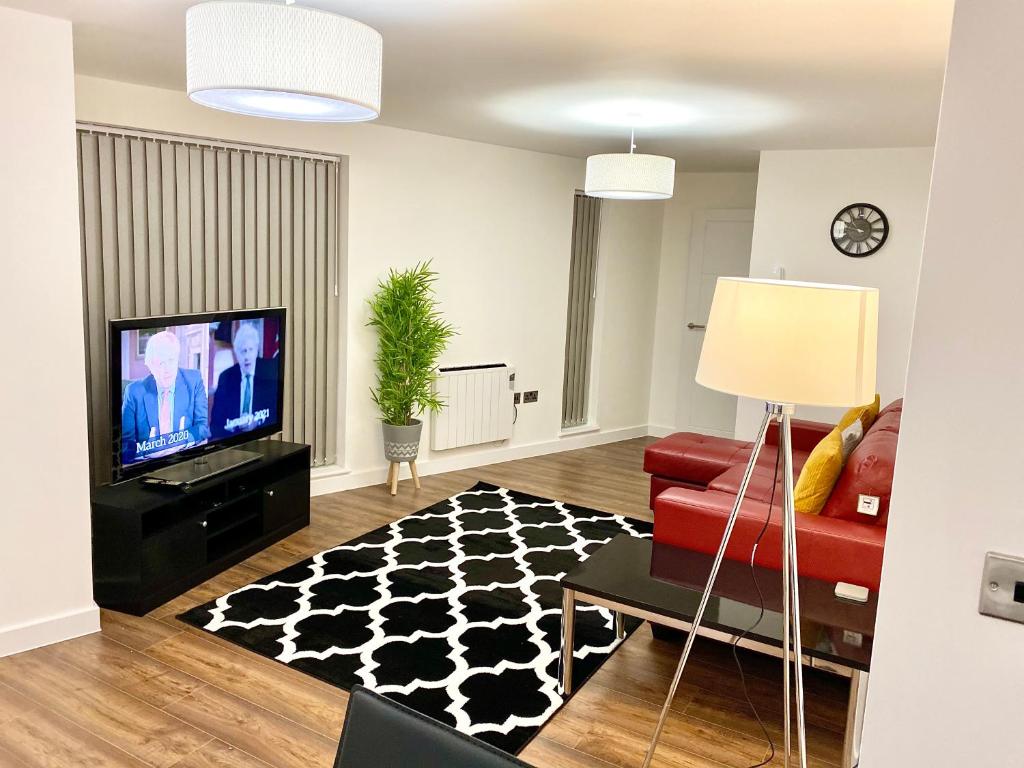 a living room with a red couch and a tv at Kings Chambers Apartments Coventry City Centre in Coventry