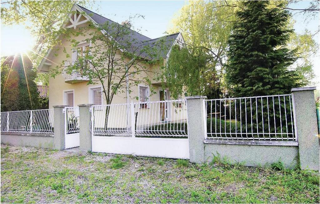 una cerca blanca frente a una casa en Tóparti Vendégház - Lipót, Magyarország, en Lipót