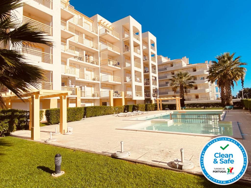 a large apartment building with a swimming pool and a sign at Vista by Check-in Portugal in Albufeira