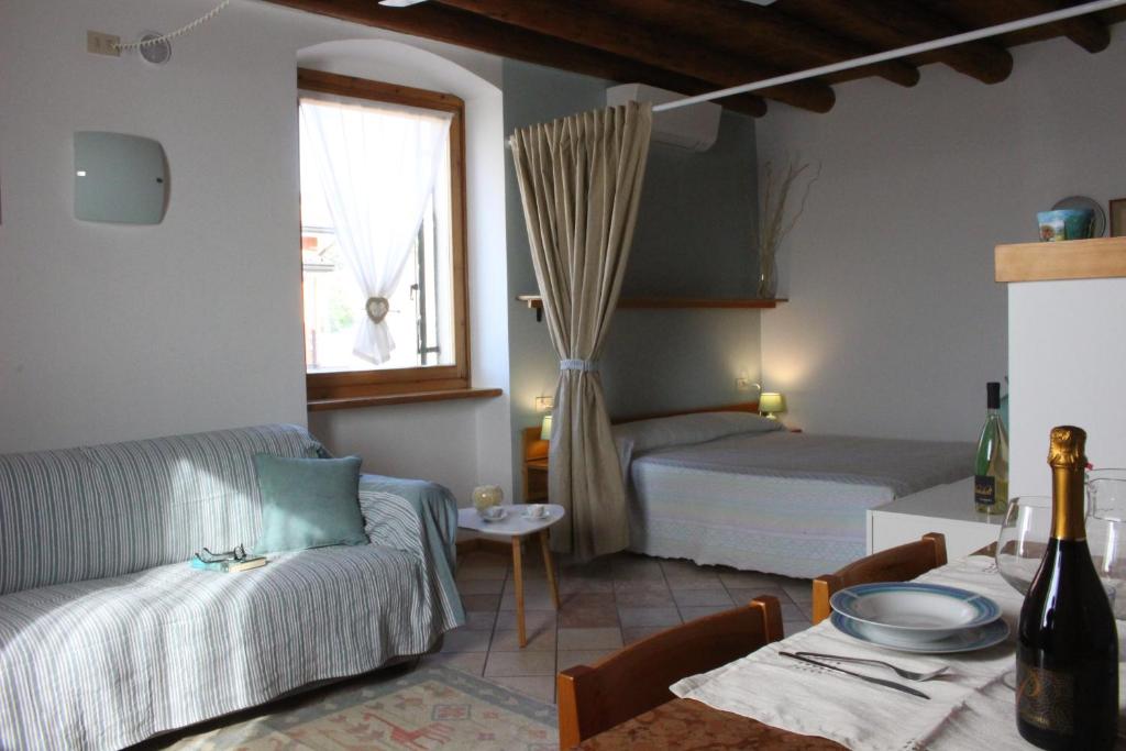 ein Wohnzimmer mit einem Sofa, einem Bett und einem Tisch in der Unterkunft Agriturismo Le Ginestre in Lazise