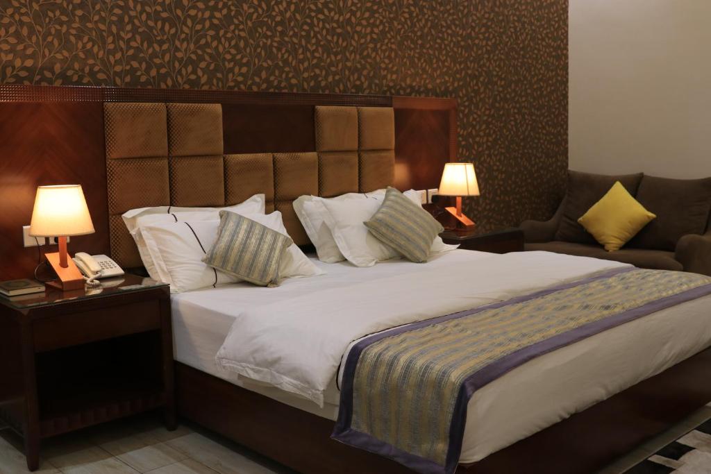 فندق درة الرؤية في جدة: غرفة نوم بسرير كبير ومصباحين