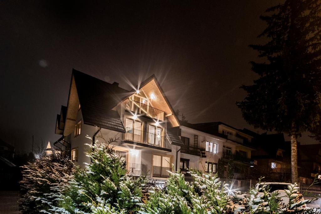 una casa iluminada por la noche con árboles de Navidad en T9 Zakopane en Zakopane