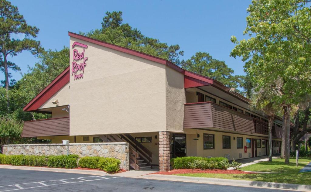 a building with a sign on the side of it at Red Roof Inn Hilton Head Island in Hilton Head Island