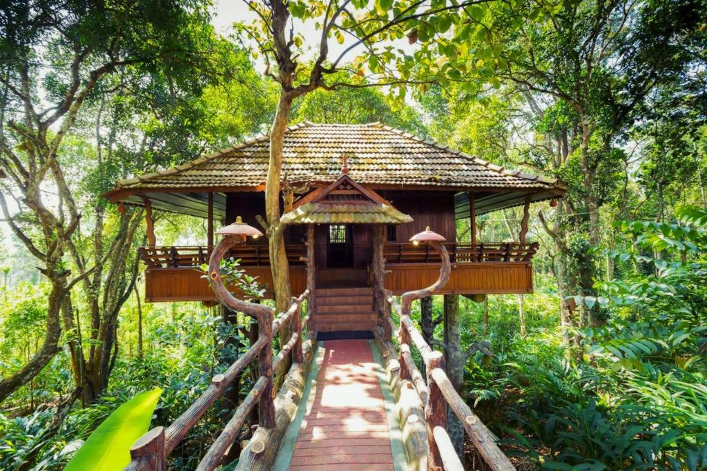 a small building in the middle of a forest at Kalpavanam Heritage Resort in Thekkady