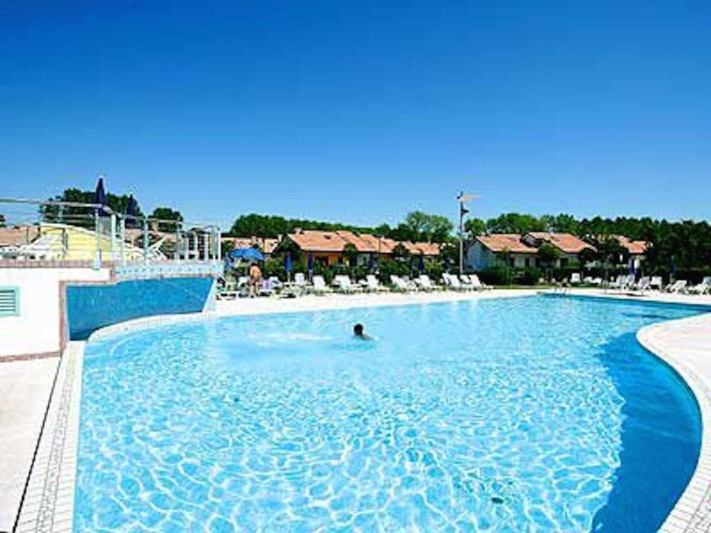 a person in a swimming pool at a resort at Casabianca Resort Villas in Lignano Sabbiadoro
