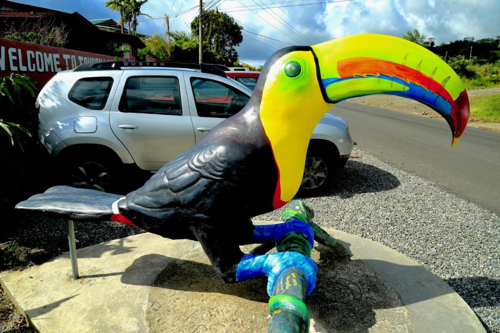 eine Statue eines Vögels auf einer Bank in der Unterkunft Toucan Lane Hotel and Restaurant in Nuevo Arenal