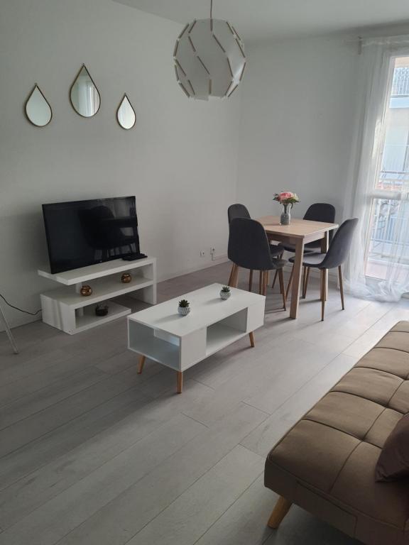 een woonkamer met een tv en een tafel bij Appartement la plage in Marseille