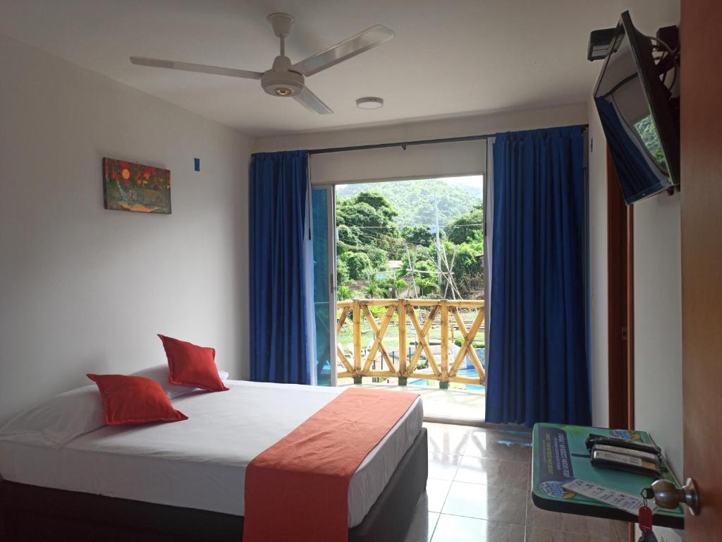 a bedroom with a bed and a large window at La Rivera Playa Palomino in Palomino