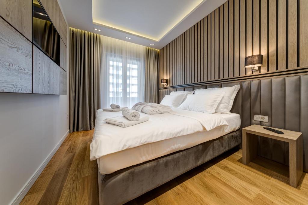 a bedroom with a large bed with towels on it at Apart Compliment in Podgorica