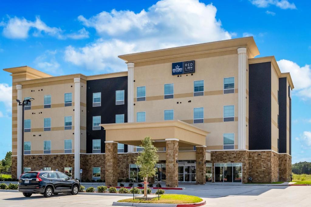 un edificio con un coche aparcado delante de él en Red Lion Inn & Suites Katy, en Katy