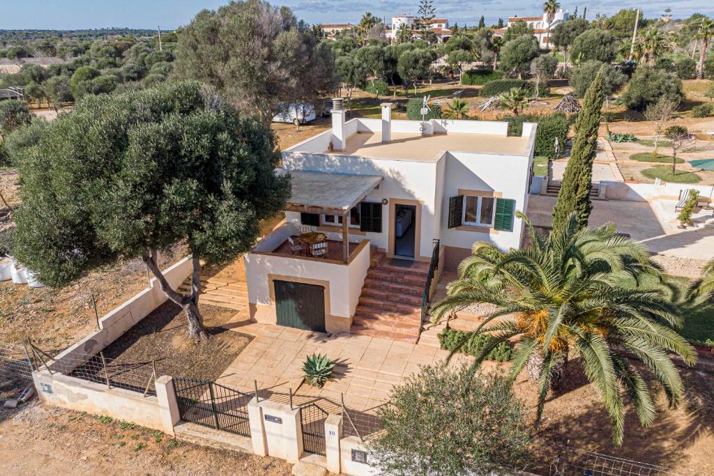 an aerial view of a white house with a palm tree at LA PLETA in Es Llombards