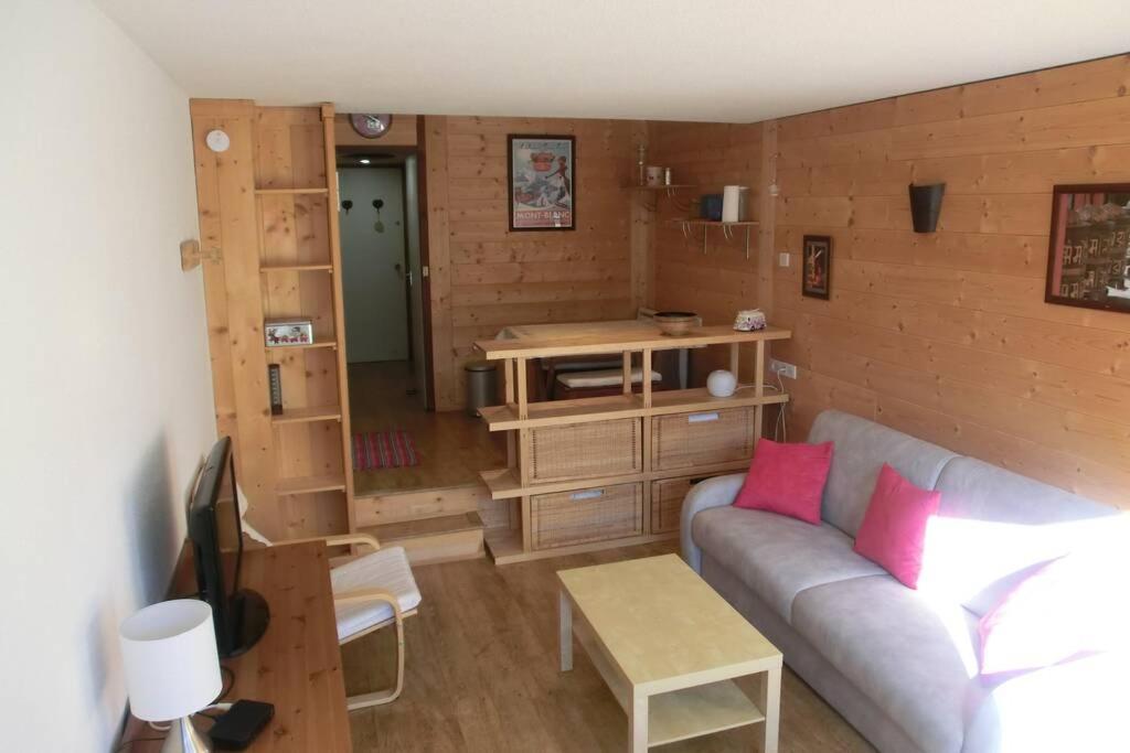 sala de estar con sofá y TV en Appartement studio front de neige, accès direct aux pistes, en Isola 2000