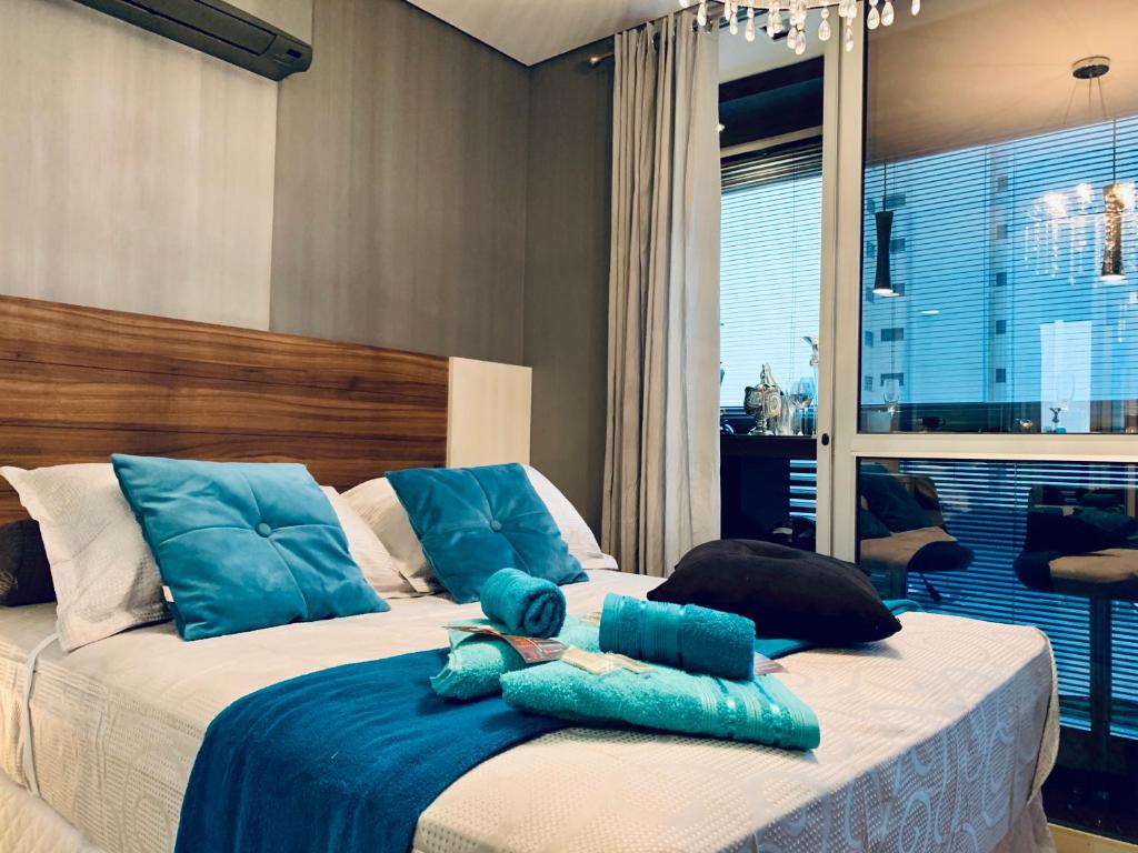 a bedroom with a large bed with blue pillows at 303 - Rentaqui - Studio Augusta Elegance Pool New in Sao Paulo