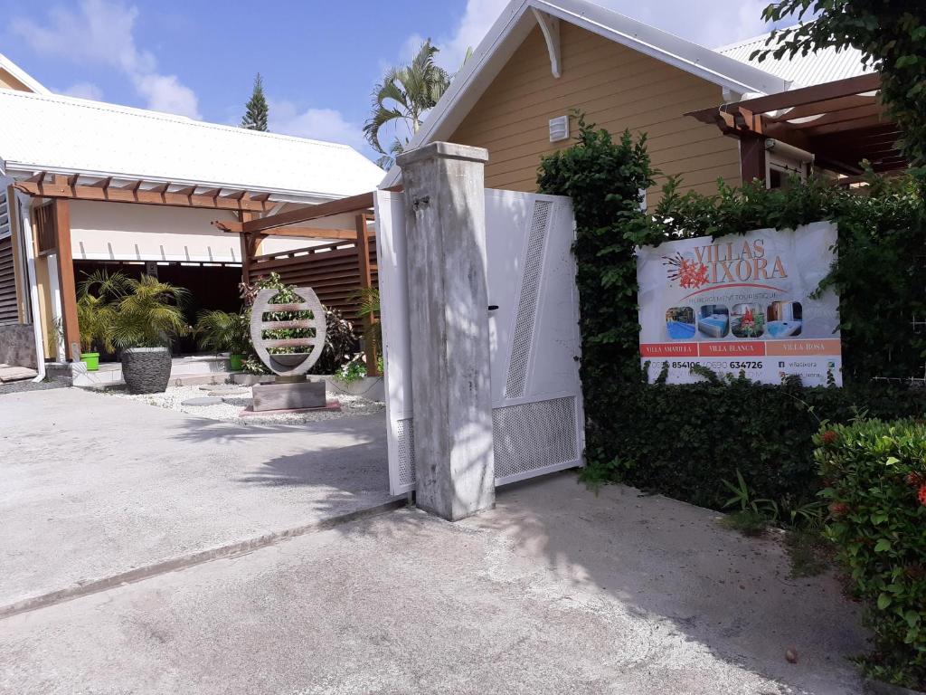 a white gate in front of a house at Villas Ixora in Sainte-Anne