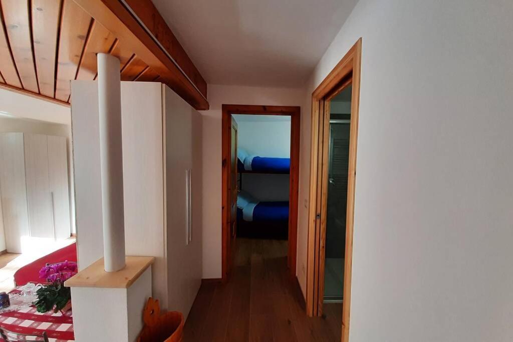 Pokój z sypialnią z łóżkiem i drzwiami w obiekcie Appartamento vicino al centro da Lori w mieście Bormio