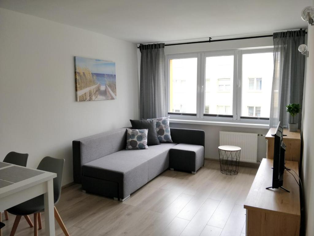 a living room with a couch and a table at Apartament Hel Leśna 8 in Hel