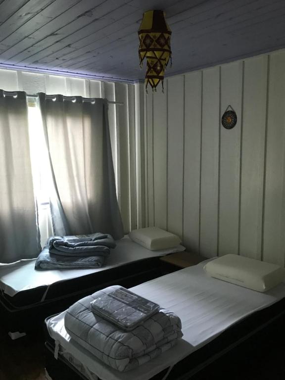 Dos camas individuales en una habitación con ventana. en Casa colonial Verde Santuário Bellatrix, en Ribeirão Amarelo