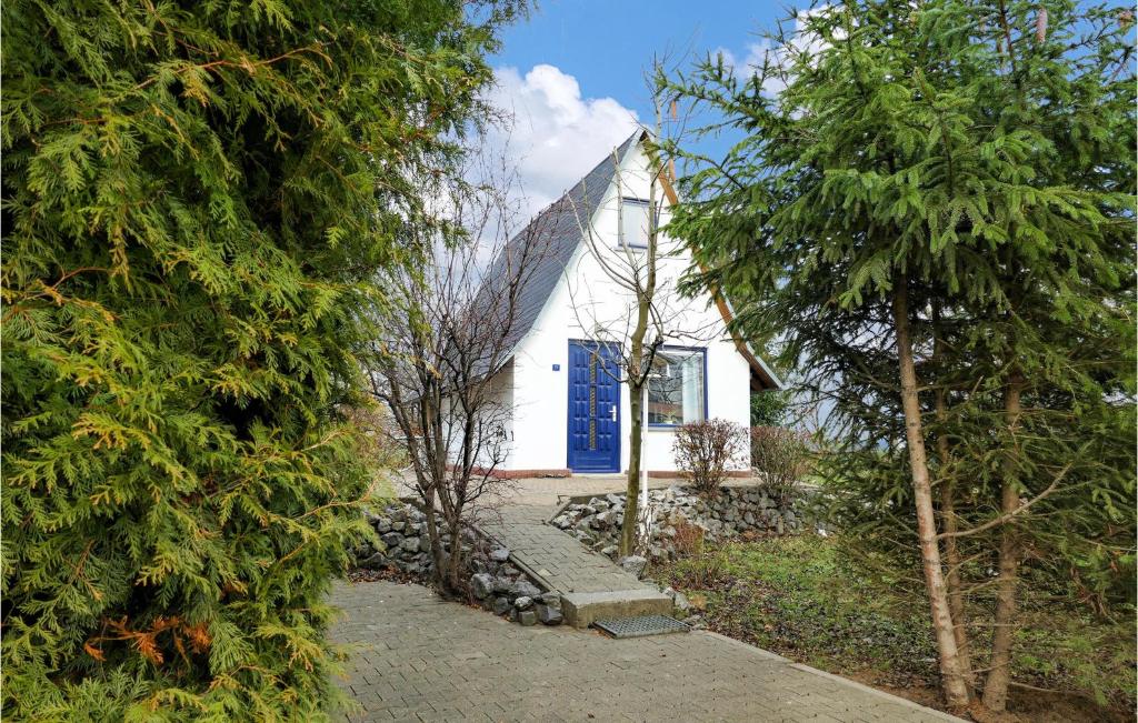 una casa blanca con una puerta azul y árboles en Lovely Home In Wernigerode With Kitchen, en Wernigerode