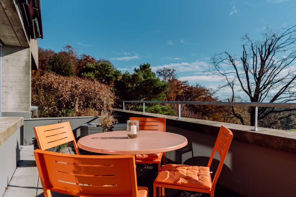 einen Tisch und Stühle auf dem Balkon in der Unterkunft findling-ferien Bern West in Säriswil