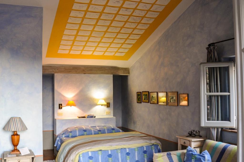 a bedroom with two beds and a yellow ceiling at Sette Querce in San Casciano dei Bagni