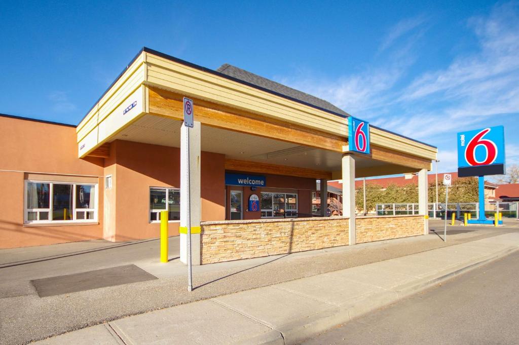 a gas station with a sign in front of it at Motel 6-Lethbridge, AB in Lethbridge