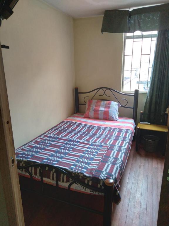 1 dormitorio pequeño con 1 cama con una manta colorida en Moraldur, en Bogotá