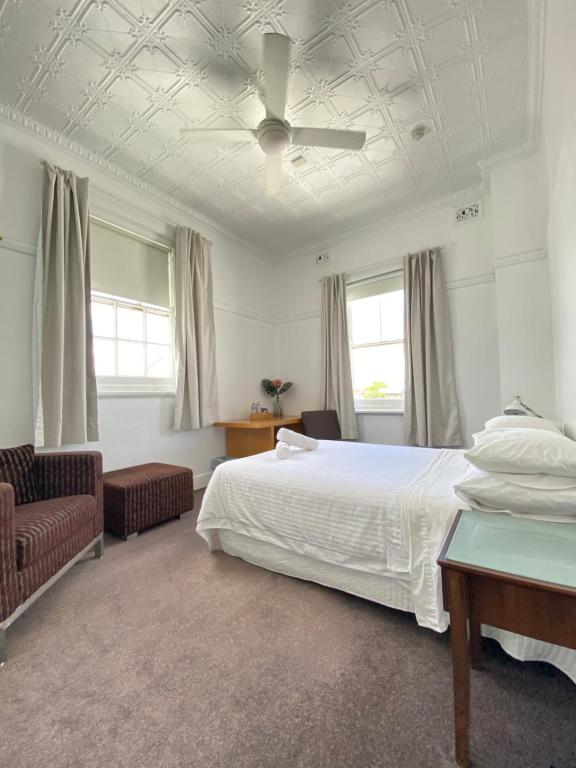 1 dormitorio con 1 cama y ventilador de techo en Newcastle Hotel en Newcastle