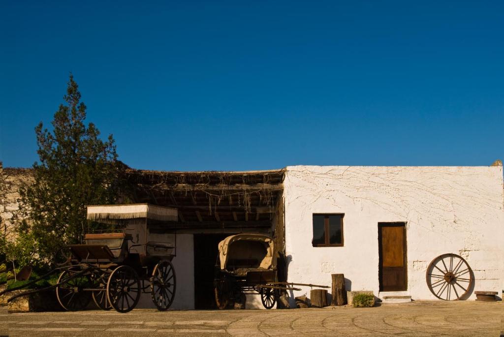 a carriage parked outside of a white building at Masseria Spina Resort in Monopoli