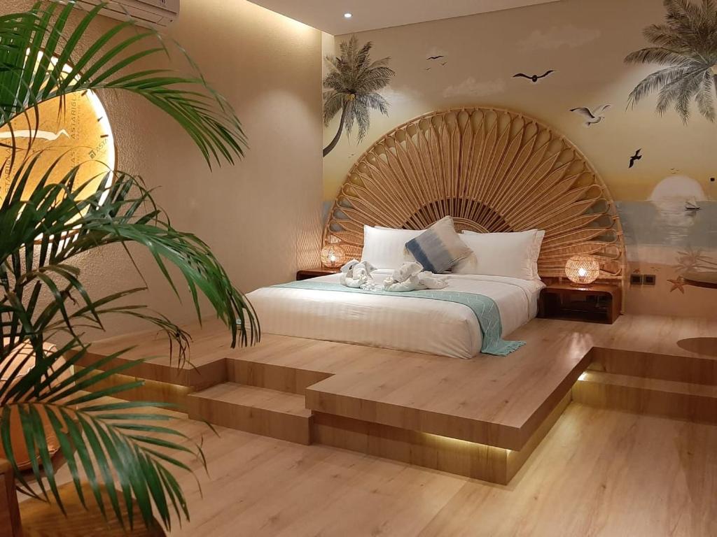a bedroom with a large bed with a wooden headboard at La Rose Villas and Suites Camp Canggu in Canggu