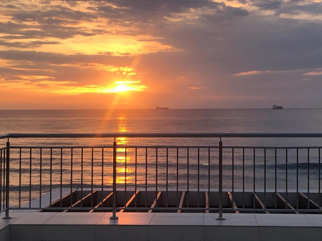 um pôr-do-sol sobre o oceano com o pôr-do-sol em Apartment 13 Santana Pebbles, 164 South Beach Road, La Mercy em La Mercy