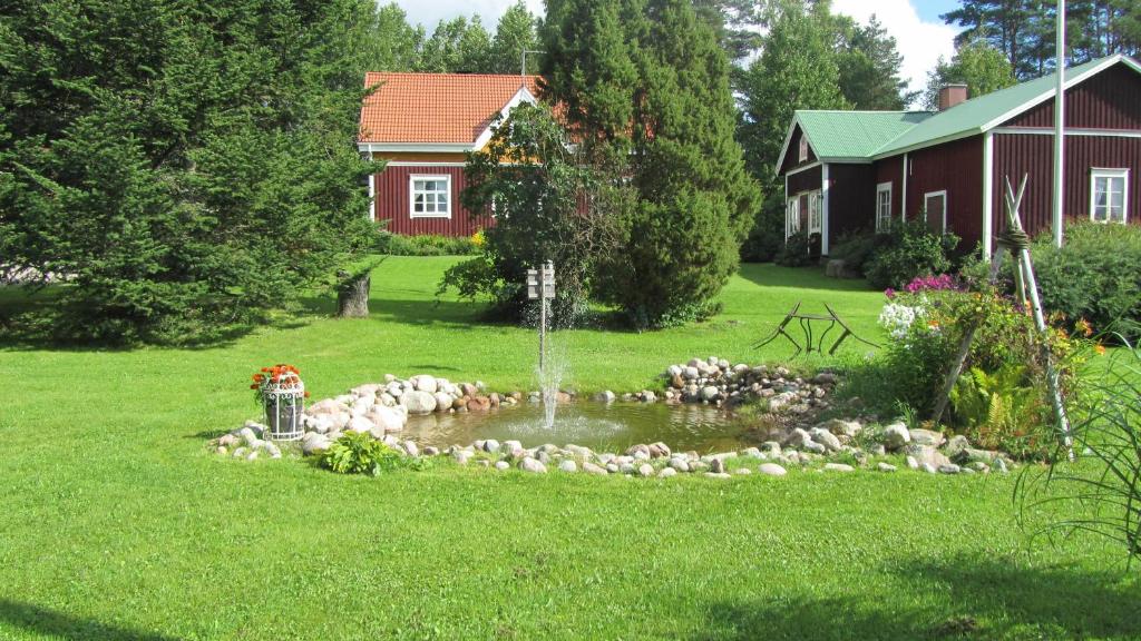 a garden with a fountain in the middle of a yard at Luomajärven Hevoskievari in Karhoinen