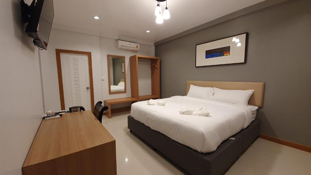 um quarto com uma cama grande e uma mesa de madeira em โรงแรมอินทราเพลส em Sakon Nakhon