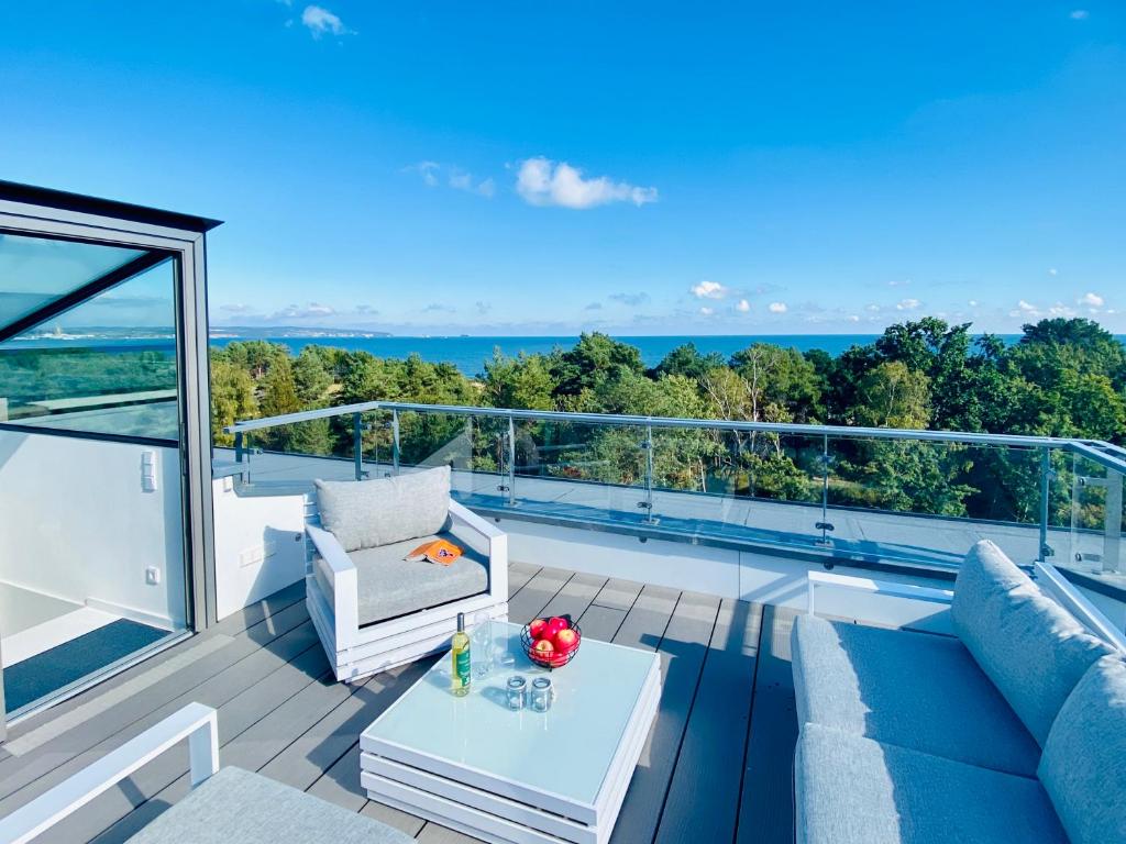 a living room with a couch and a table on a balcony at Penthouse mit Dachterrasse PIER 5.4 in Binz
