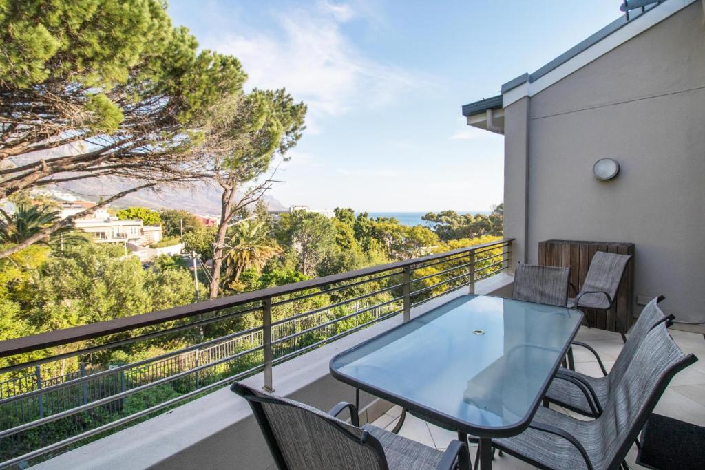 a balcony with a table and chairs on a building at The Glen Apartments in Cape Town